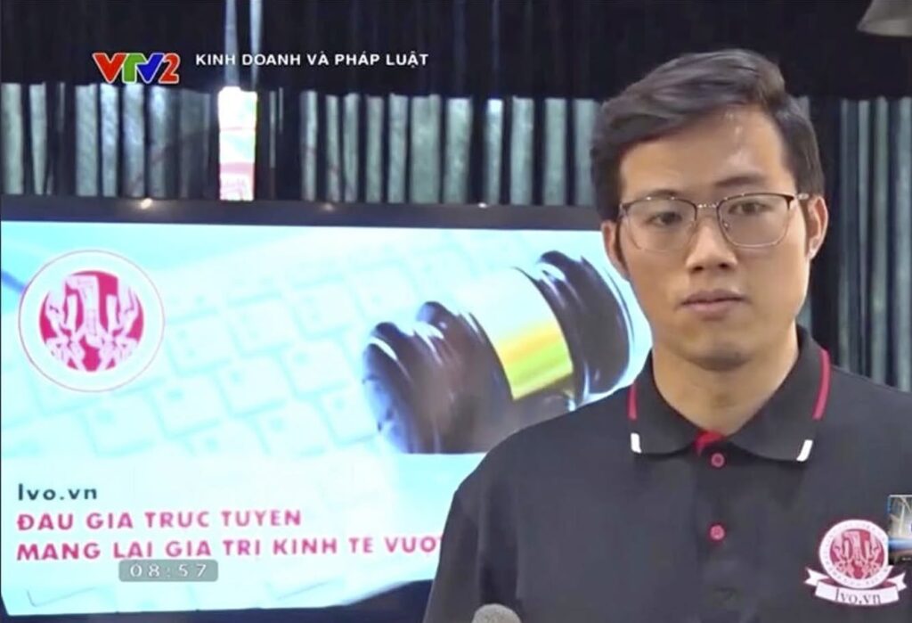 Nguyễn Trọng Hùng discussing online auctions in a supplied VTV2 broadcast still.
